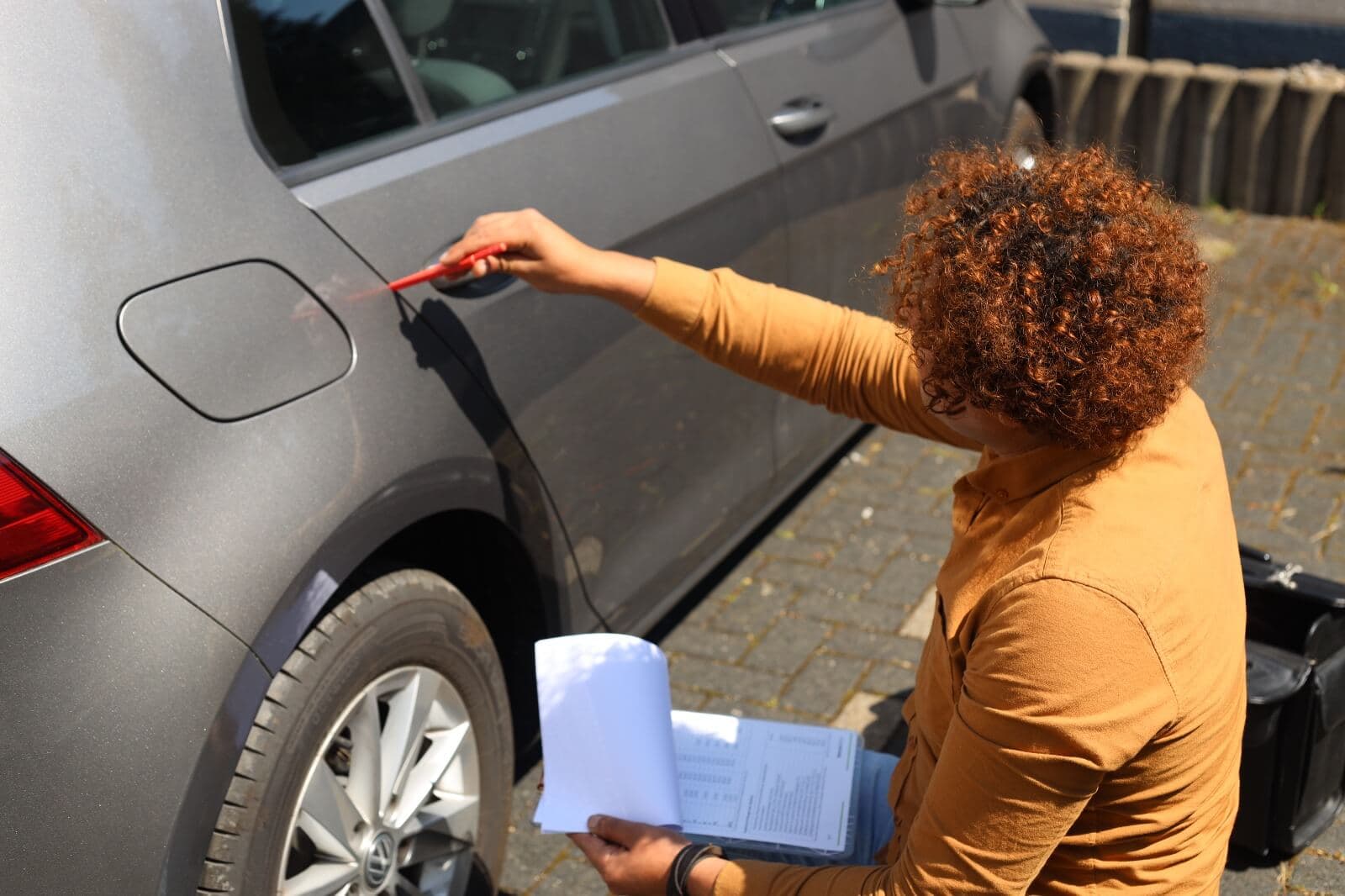 Sachverständiger dokumentiert einen Lackschaden an einem Fahrzeug